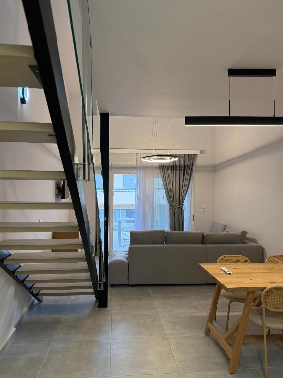 a living room with a couch and a table at RoomElioti Apartments in Ofrínion