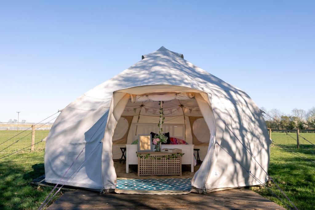 a tent with a table in it in a field at Nine Acres, Hot Tub, peaceful in Brackley