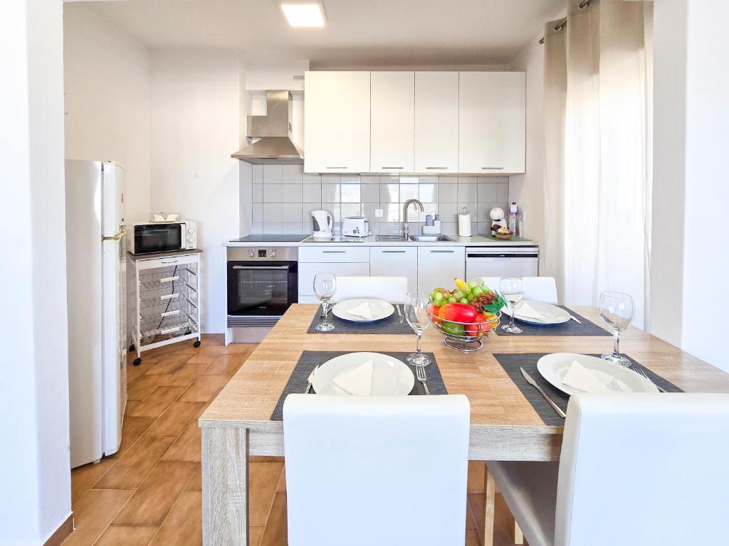 ポルティマンにあるApartment Panorama Rocha Serenityのキッチン(木製テーブル、白いキャビネット付)