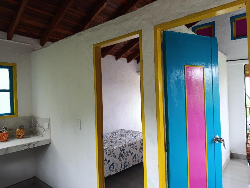 a room with a colorful door and a bed at La cabaña - Finca los Martinez in Támesis