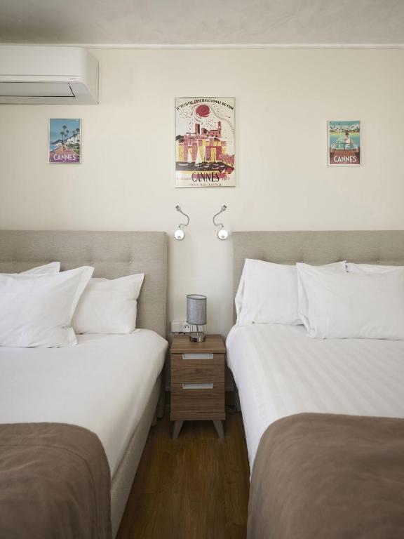two beds sitting next to each other in a room at Hotel des Congrès et Festivals in Cannes