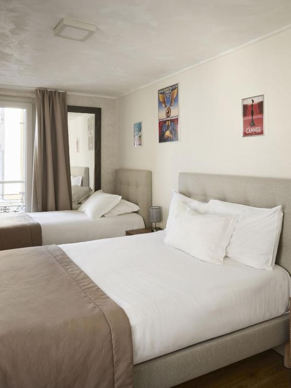 two beds in a hotel room with white walls at Hotel des Congrès et Festivals in Cannes