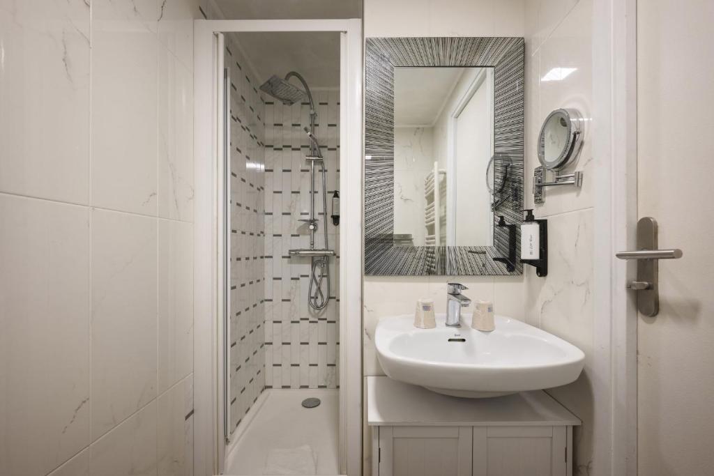 a white bathroom with a sink and a shower at Hotel des Congrès et Festivals in Cannes