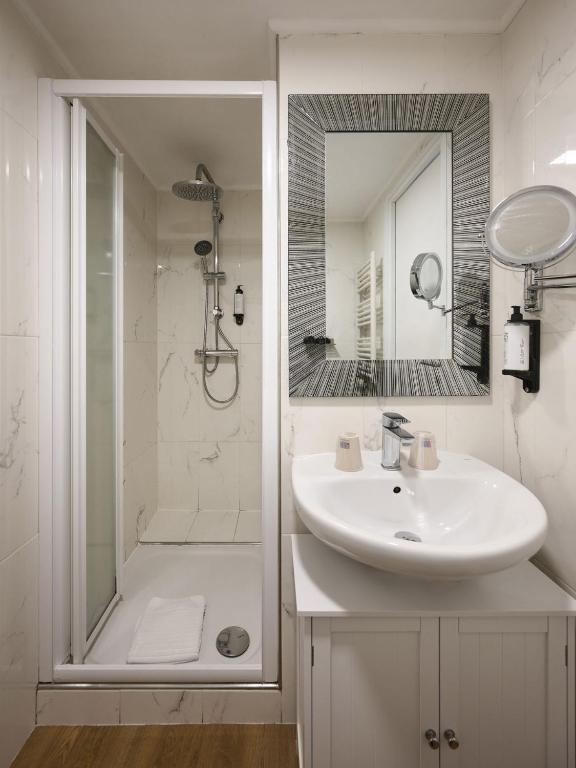 a white bathroom with a sink and a shower at Hotel des Congrès et Festivals in Cannes