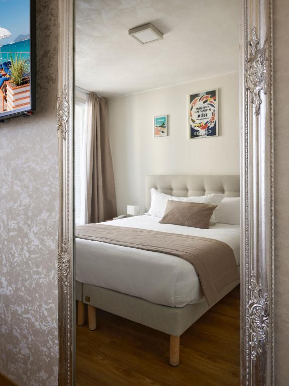 a large mirror in a bedroom with a bed at Hotel des Congrès et Festivals in Cannes