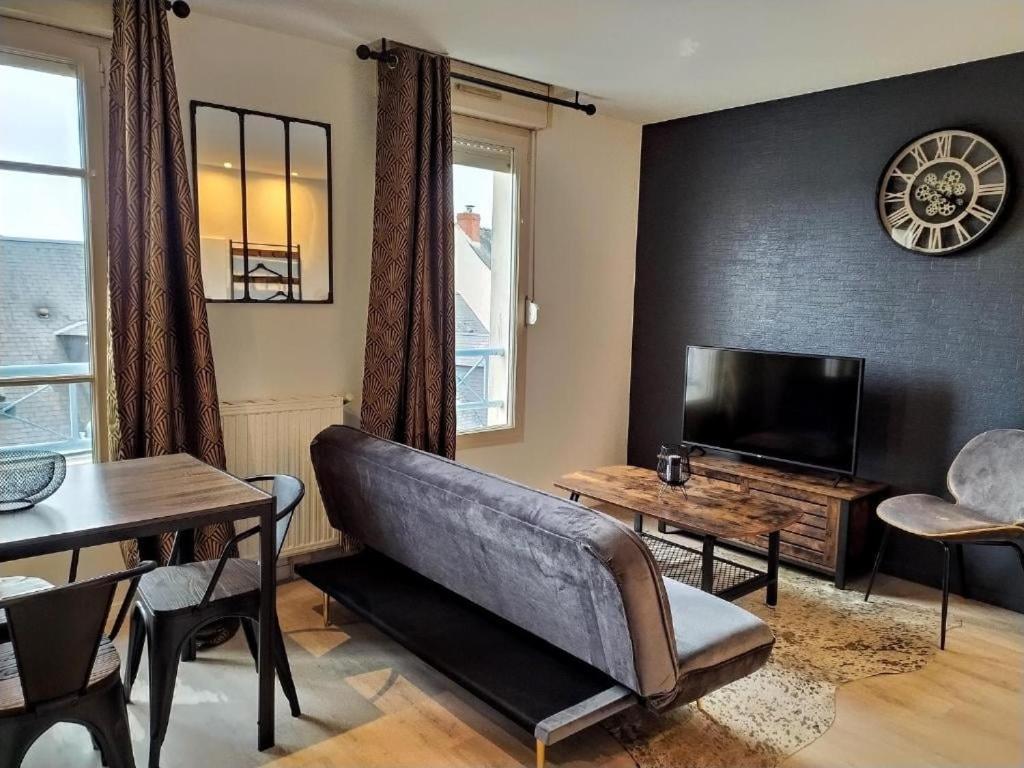 un salon avec un canapé et une télévision dans l'établissement OIQIA • Industriel, au Mans