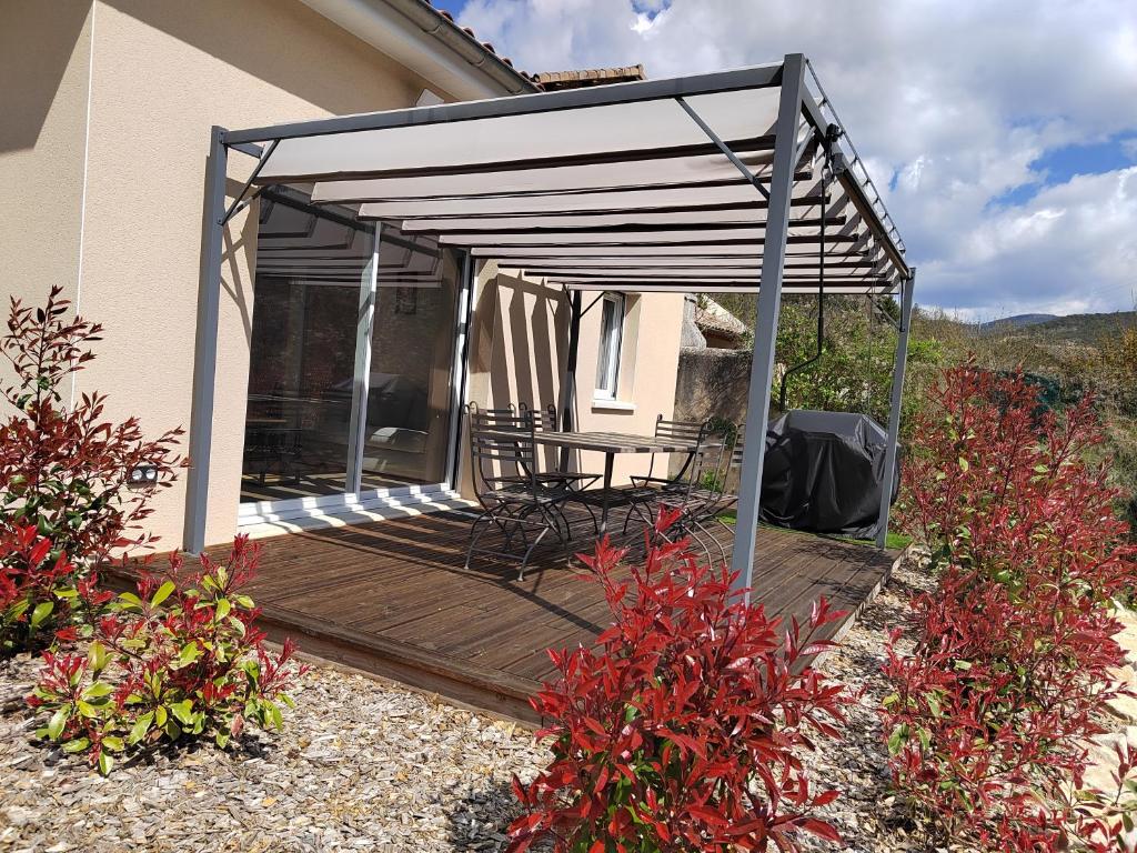 Montclar-sur-GervanneにあるGîte Le Chaudron 1 à 7pers avec piscineのデッキにテーブルと椅子が置かれたパティオ