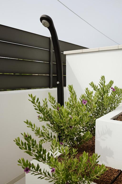 a street light on the side of a house with plants at AR Palace Hotel - Palermo in Isola delle Femmine