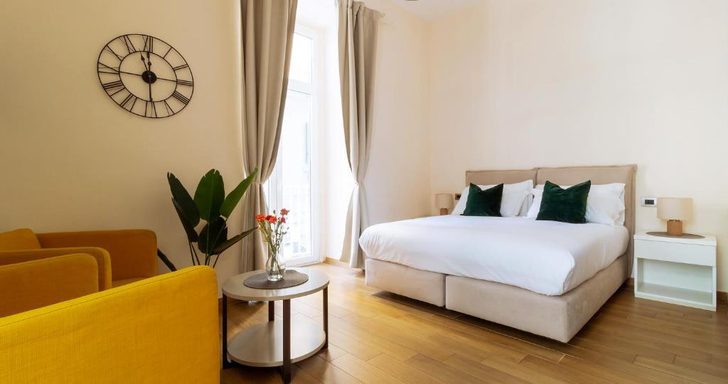 sypialnia z łóżkiem, kanapą i zegarem w obiekcie Musto Suites & Rooms w mieście Neapol