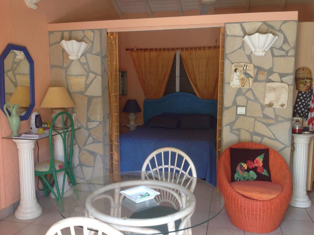 a bedroom with a bed and a table and chairs at Sun Caraibes in Orient Bay