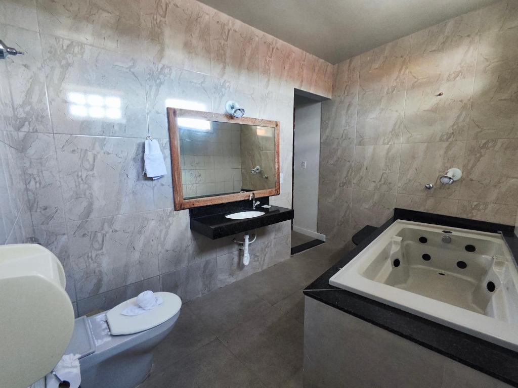 un bagno con vasca, WC e lavandino di POUSADA FLOR DE LIS a Diamantina