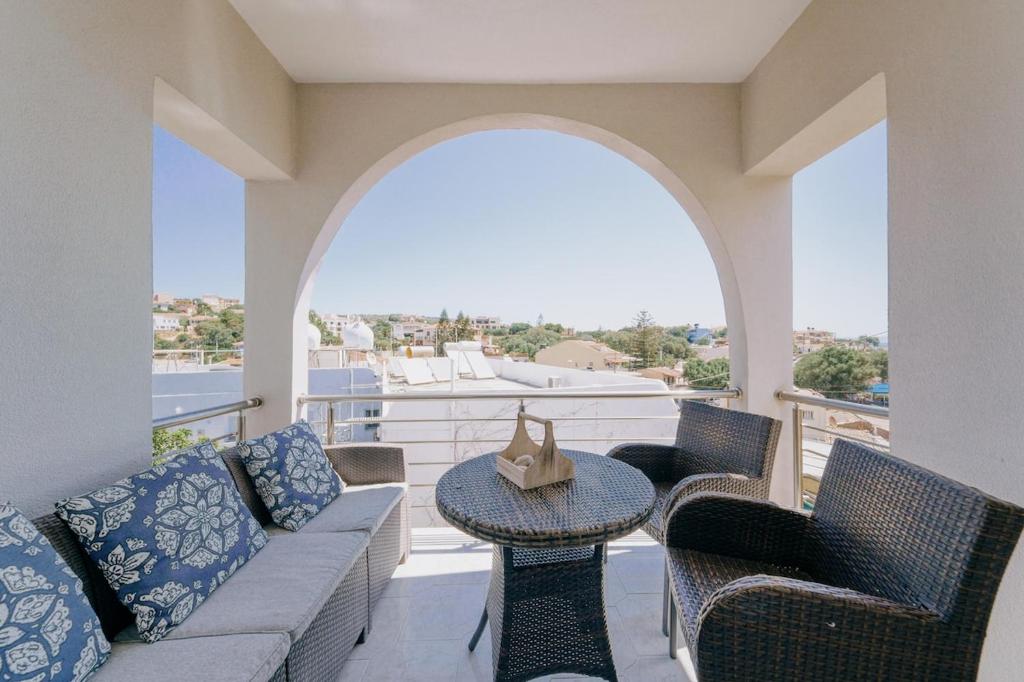 balcón con sofá, sillas y mesa en Sofia's Apartment, en Chios