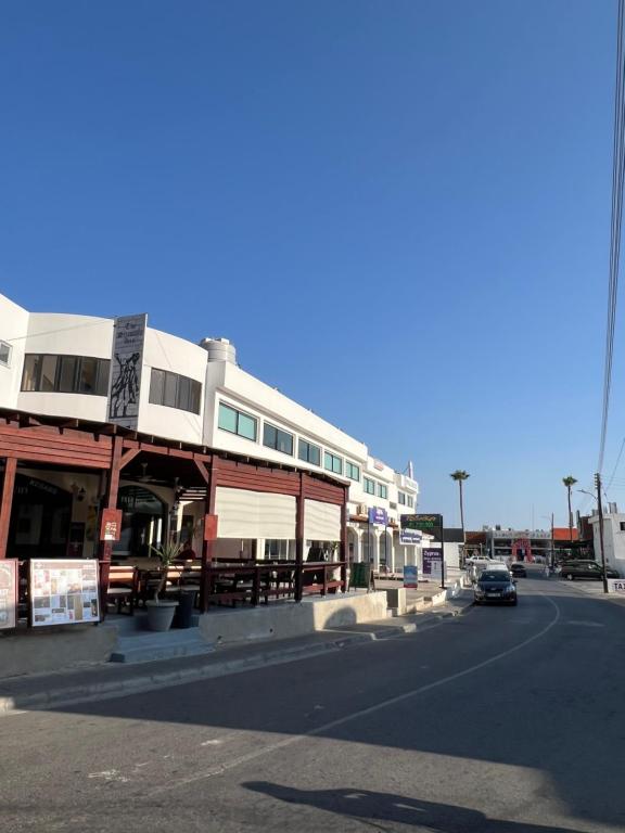 a car driving down a street next to a building at Living Boutique Apartments Adults Only in Ayia Napa