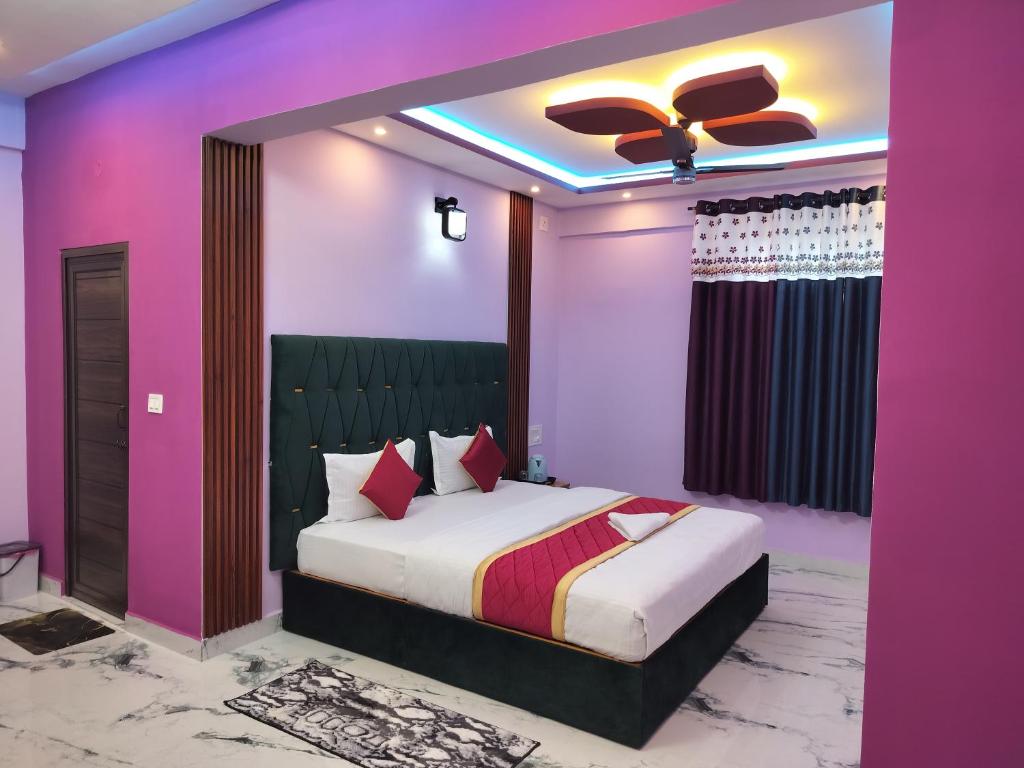 1 dormitorio con 1 cama grande y paredes de color rosa en Blue Bell Home Stay, en Madikeri