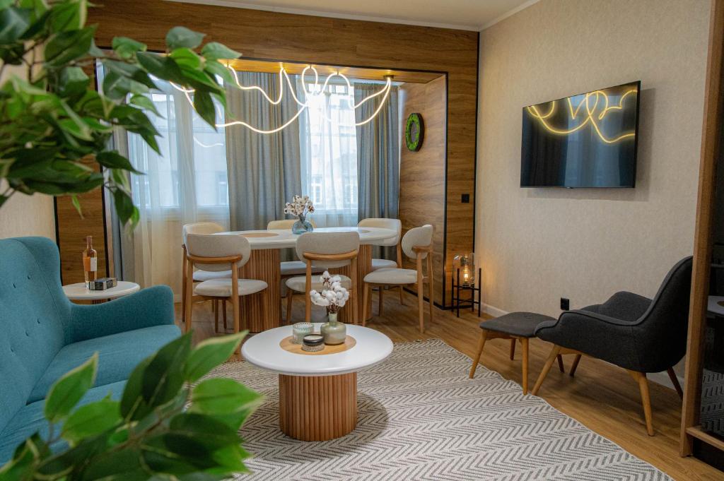 ein Wohnzimmer mit Tisch und Stühlen in der Unterkunft Golden Light - 3BR Luxury Central in Bŭnzareto