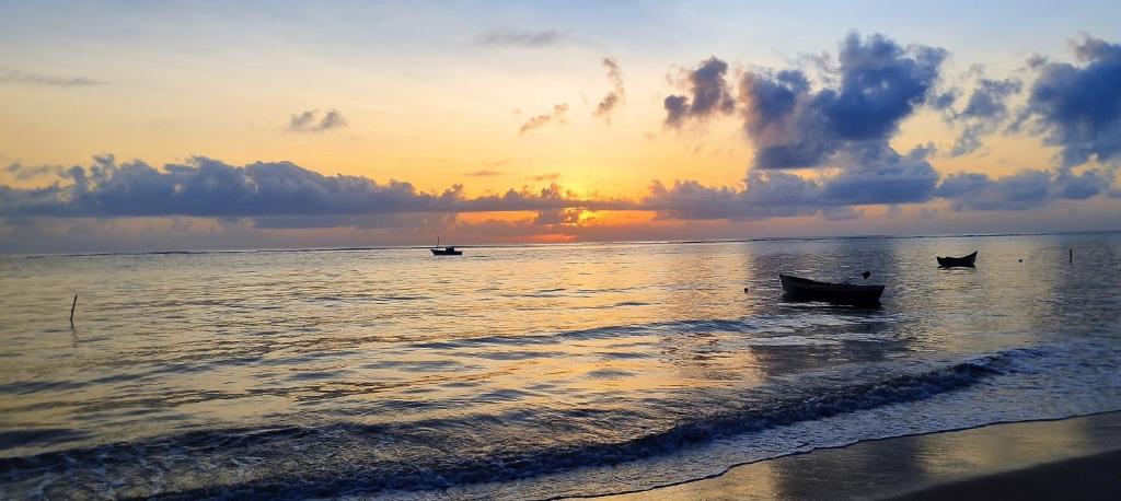 two boats on the water at the beach at sunset at Casa de Praia Caminho das Indias in Coroa Vermelha