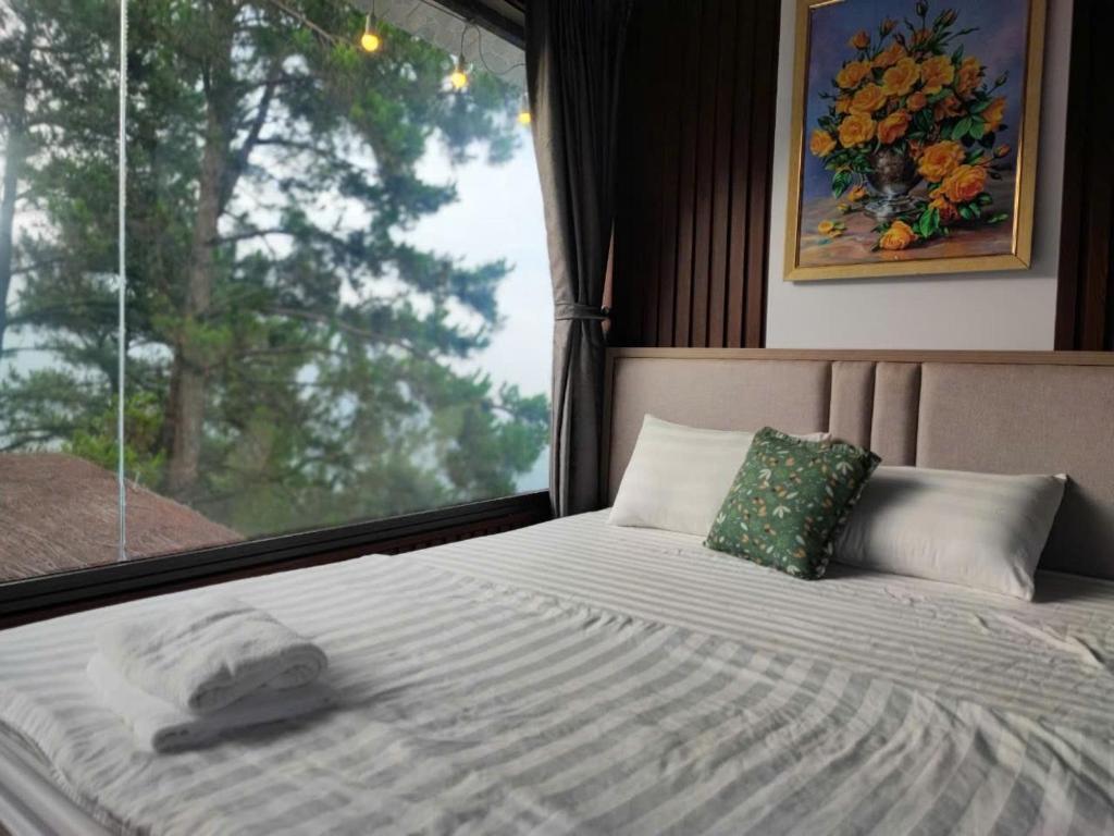 a bed in a room with a window at Mimosa 228-phòng săn mây in Tam Ðảo