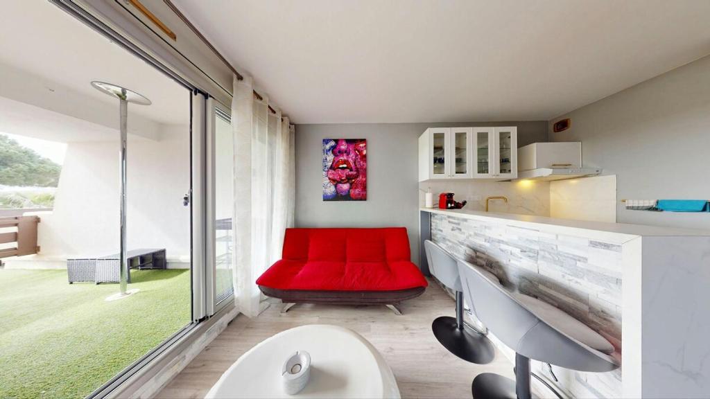 une salle de bains avec un banc rouge et un siège rouge dans l'établissement Le Cocon Port Nature 5 Village Naturiste Cap d'Agde, au Cap d'Agde