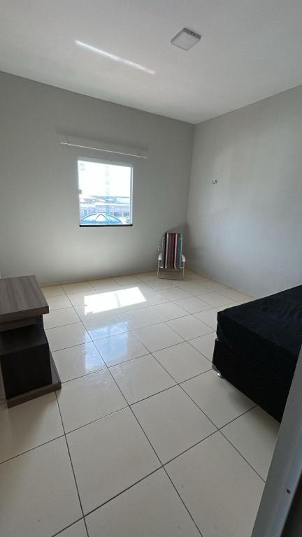 a large white room with a bed and a window at Apartamento Centro de Tauá in Tauá