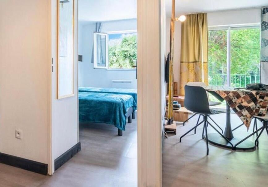Cette chambre comprend un lit et une table avec une chaise. dans l'établissement Appartement aux portes de Saint-Tropez, à Saint-Tropez