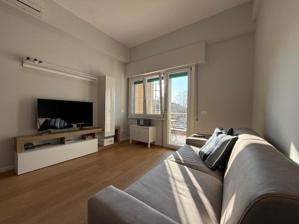 a living room with a couch and a television at Casa Vacanze Stella Maris in Lido di Ostia