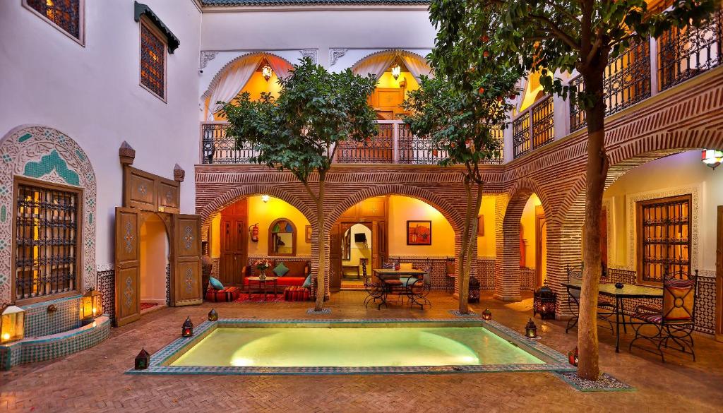 a house with a pool in a room with a tree at Riad Fleur d'Orient in Marrakech
