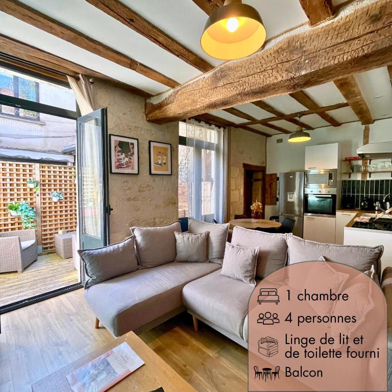 un salon avec un canapé et une cuisine dans l'établissement La Porte Chartraine - Appartement avec terrasse au coeur de Blois, à Blois