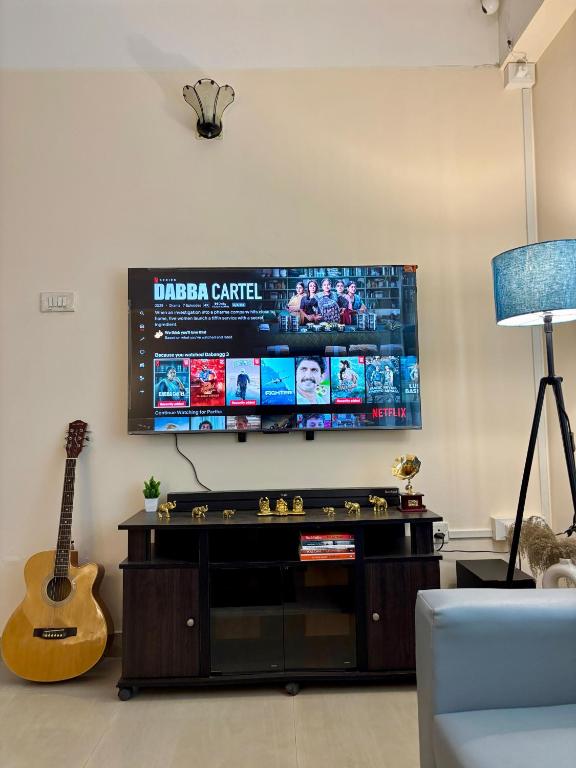 a living room with a entertainment center with a video game at Placid Homestay in Guwahati