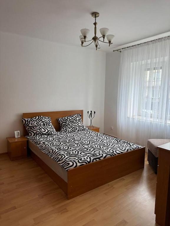 a bedroom with a bed with a black and white comforter at Apartament Krola Stefana Batorego in Kielce