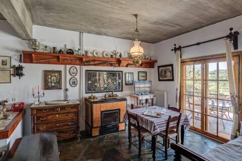 a living room with a table and a kitchen at Lilly Traditional Cretan Villa in Dhrakóna