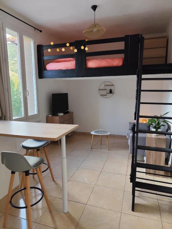 Cette chambre comprend une table et des lits superposés. dans l'établissement Cocoon en bas du Faron, à Toulon
