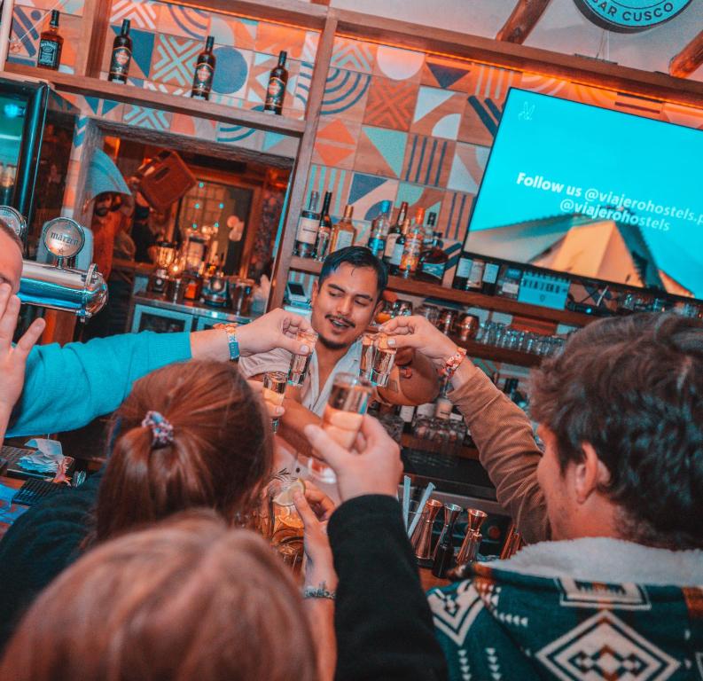 a group of people drinking at a bar at Viajero Cusco Hostel in Cusco