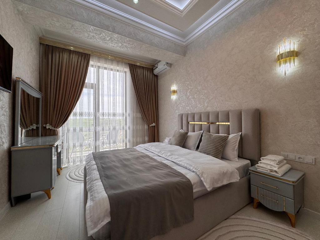 a bedroom with a large bed and a television at Samarkand Premium Apartment 1 in Samarkand