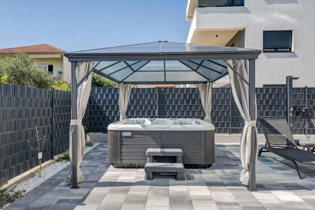a gazebo with a table and a chair on a patio at Luxury apartment with jacuzzi in Trogir in Trogir