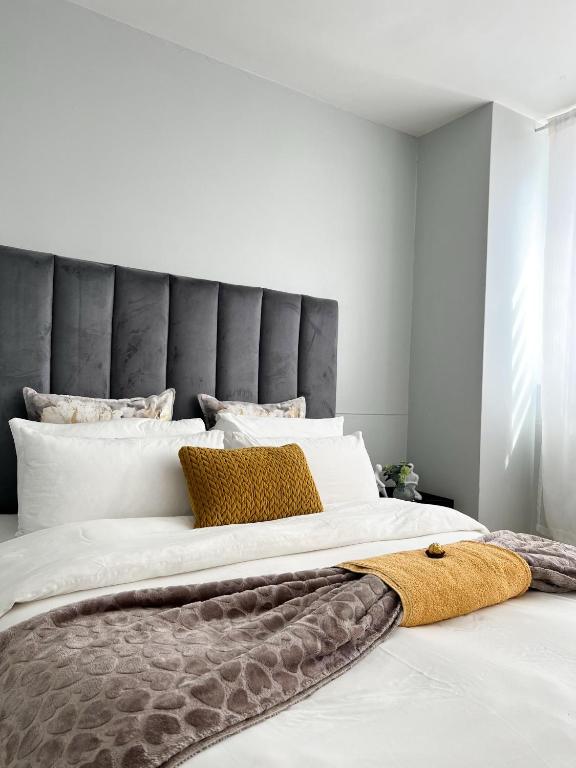 a bedroom with a large bed with a gray headboard at C&J city centre Airbnb in Windhoek