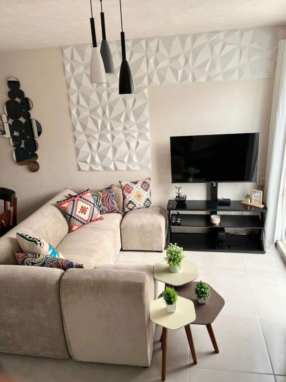 a living room with a couch and a flat screen tv at Hermosa casa alberca climatizada in San Baltasar