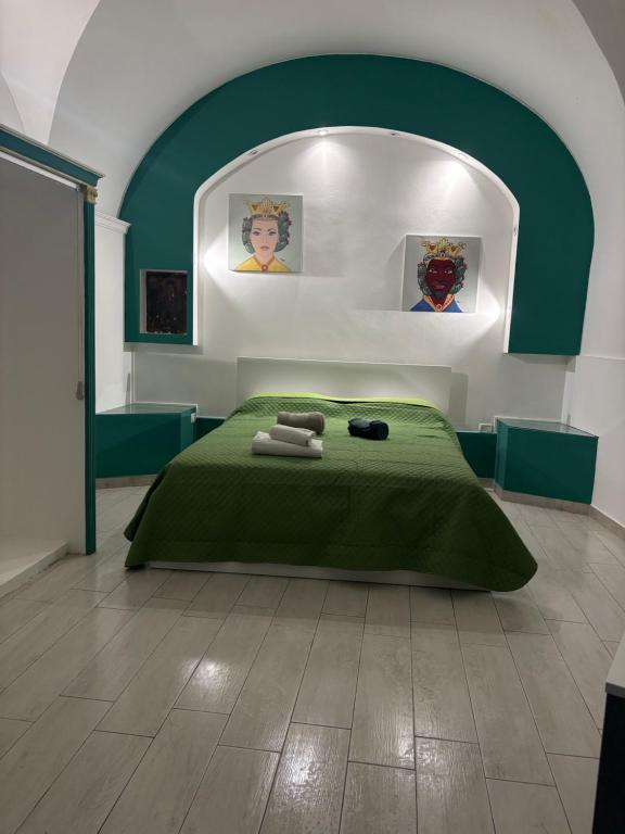 a bedroom with a green bed with towels on it at La maison des marins in Catania
