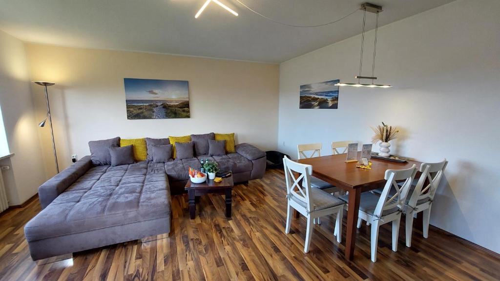 een woonkamer met een bank en een eettafel bij Fewo Flutbarke in Wilhelmshaven