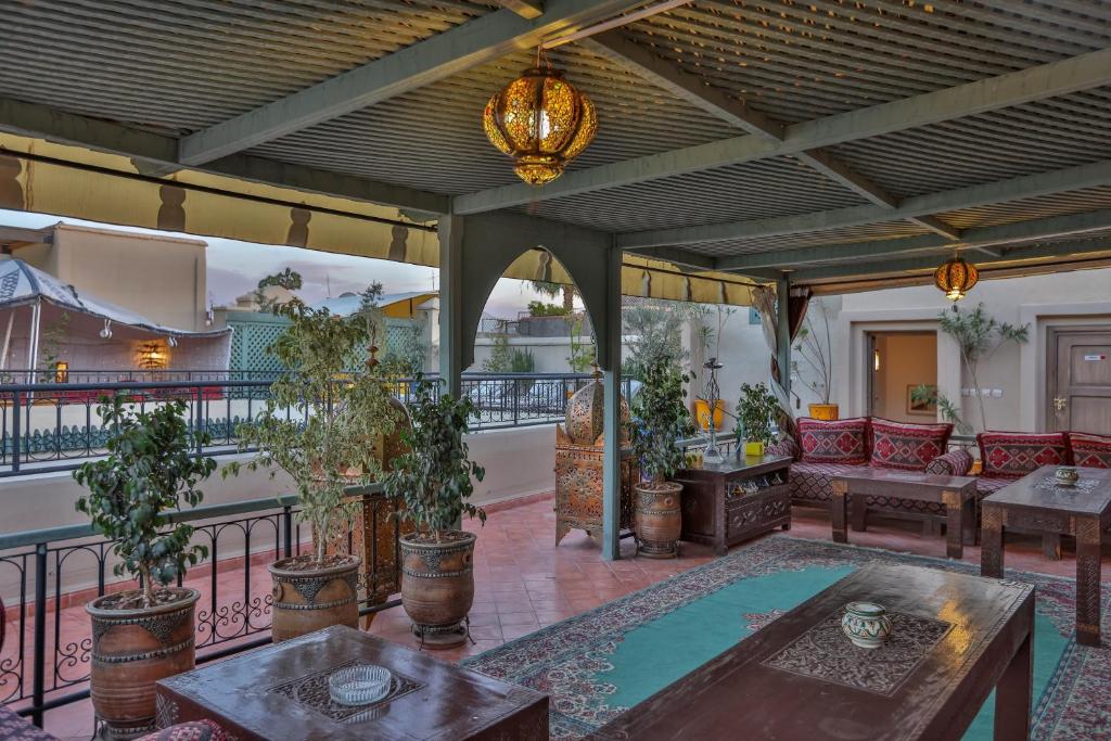 an outdoor living room with a table and chairs at Riad Fleur d'Orient in Marrakech