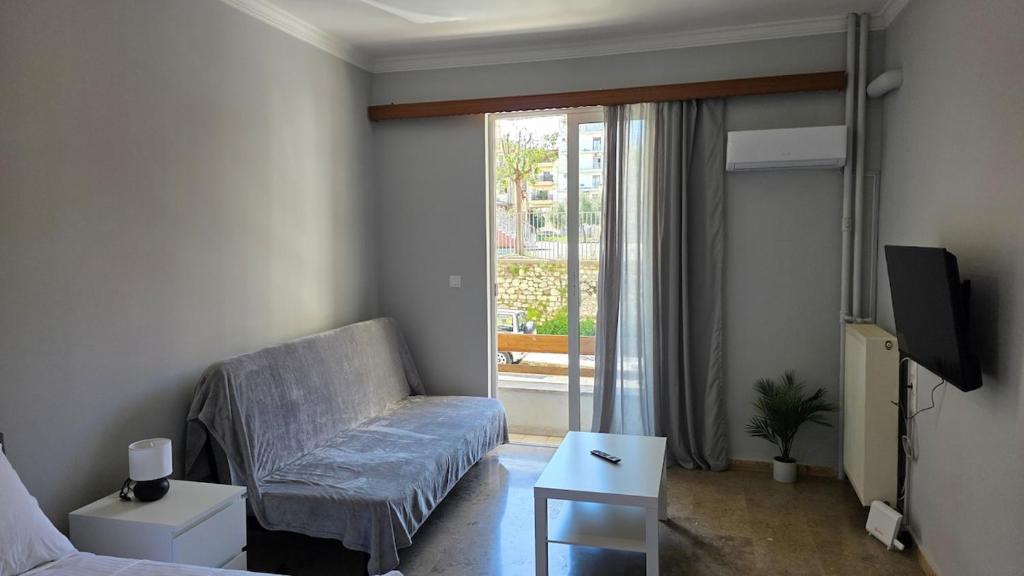 a living room with a couch and a tv at Cozy Studio 6 in Patra