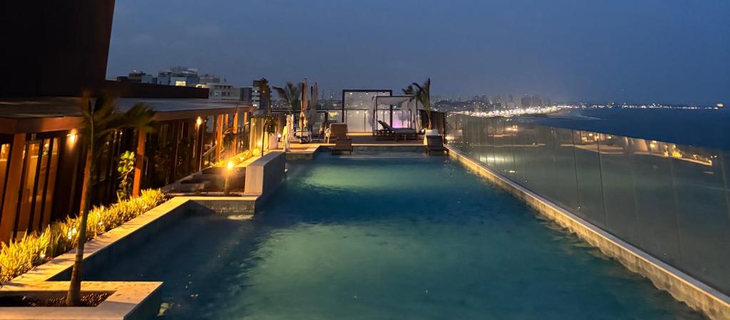 una piscina con vistas al océano por la noche en Frente Mar Salvador Bahia, en Salvador
