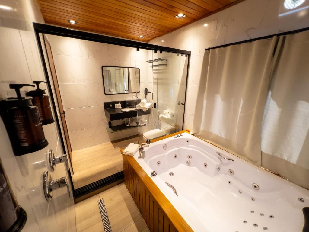 a large bathroom with a tub and a shower at Vila Chamonix - Chalé Malbec in Urubici