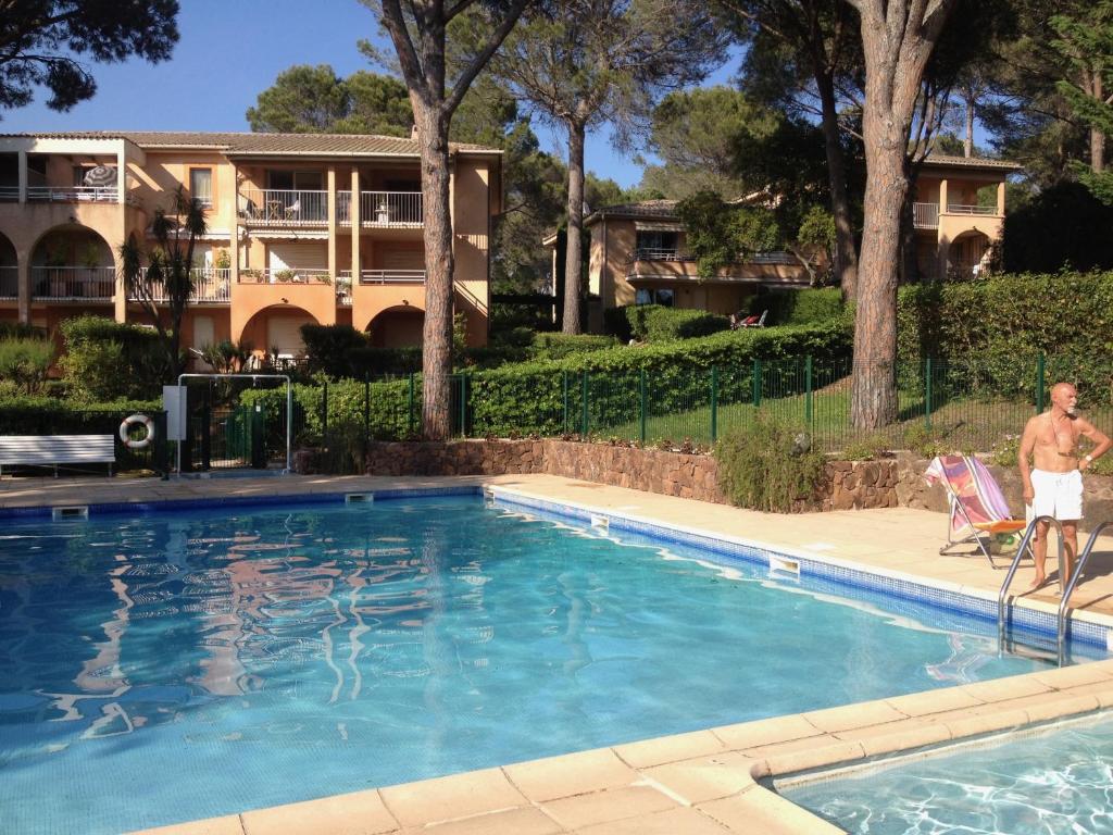 un homme debout sur une chaise à côté d'une piscine dans l'établissement Appartement Valescure au cœur des golfs, à Saint-Raphaël