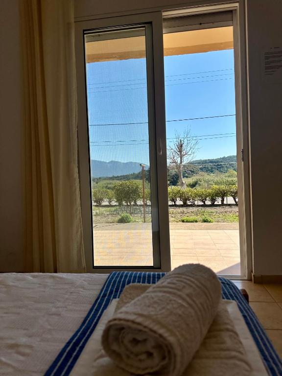 a bedroom with a bed with a view of a window at Garden View Appartment (Thanasis) in Kalavárda