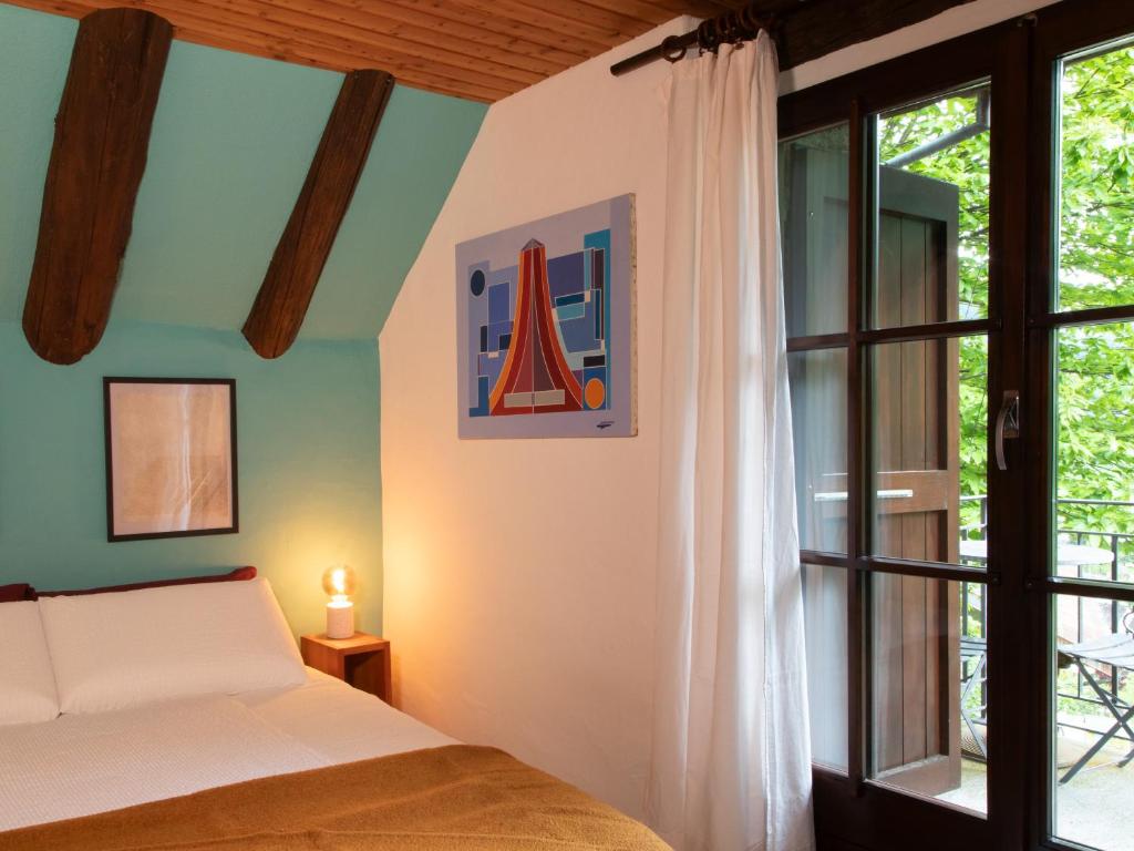 a bedroom with a bed and a window at Verzasca Lodge Cassiopea in Frasco
