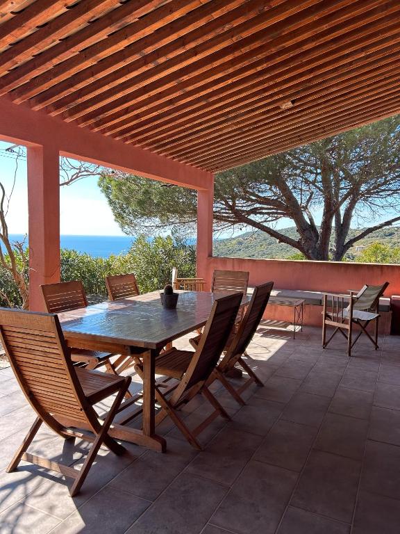 une table et des chaises en bois sur une terrasse dans l'établissement Villa Stella Di Mare, à Coti-Chiavari