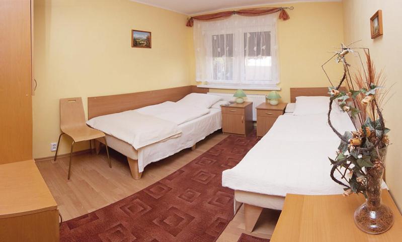 a bedroom with two beds and a window at Dom Gościnny Pod Brzozami in Poznań