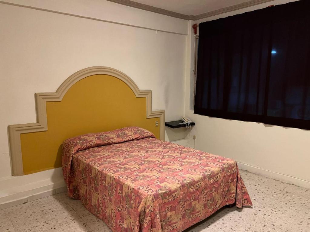 ein Schlafzimmer mit einem Bett und einem großen Fenster in der Unterkunft Hotel y Restaurant Real Plaza Jacona in Ciudad Valles