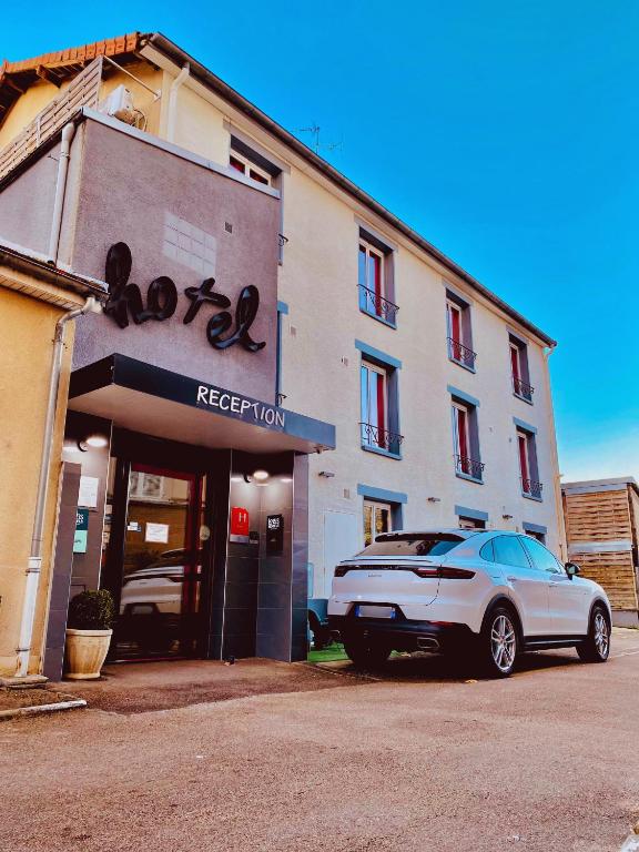 une voiture blanche garée devant un hôtel dans l'établissement Appart du cirque centre historique, à Troyes