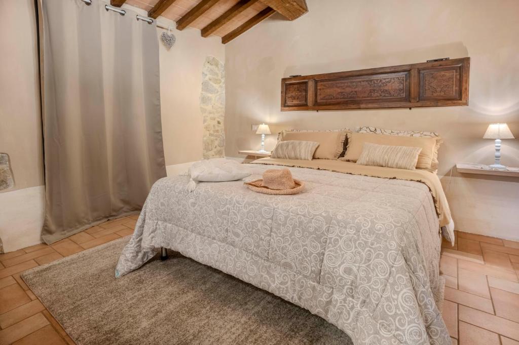 une chambre avec un lit avec un chapeau dessus dans l'établissement Cottage La Dolce Agogia Panicale, à Panicale